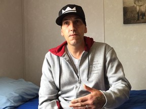 Joey, who has been homeless for a couple of years and has most recently lived in a shelter, sitting on a new bed in temporary modular housing that will open June 19 in Surrey.