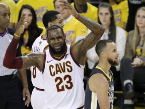 Cleveland Cavaliers forward LeBron James (23) reacts next to Golden State Warriors guard Stephen Curry during the first half of Game 2 of basketball's NBA Finals in Oakland, Calif., Sunday, June 3, 2018.