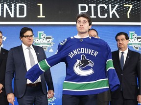 Quintin Hughes, selected seventh overall in Friday's NHL Entry Draft, dons a Vancouver Canucks jersey in Dallas.