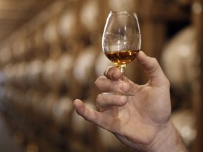 FILE - In this May 20, 2009 file photo, a glass of Jack Daniel's whiskey is examined after being taken from an aging barrel in one of the barrel houses at the distillery in Lynchburg, Tenn. American distilleries large and small have watched warily as rhetoric about tariffs has ratcheted up. Export revenues for bourbon, Tennessee whiskey and rye whiskey products topped $1 billion in 2017, continuing a trend in recent years, according to the Distilled Spirits Council.