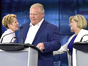 Ontario Liberal Leader Kathleen Wynne, left, shakes hands with Ontario NDP Leader Andrea Horwath, right, behind Ontario Progressive Conservative Leader Doug Ford following the end of the third and final televised debate of the provincial election campaign in Toronto, Sunday, May 27, 2018.