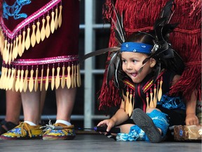 A child plays on stage as First Nation dancers celebrate as The City of Vancouver, together with Musqueam, Squamish and Tsleil-Waututh, announce new, Indigenous names for the Vancouver Art Gallery north plaza and the Queen Elizabeth Theatre Plaza.