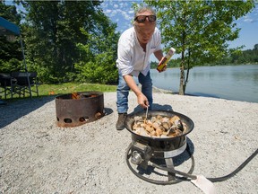 Larry Pynn lights a propane fire (wood fire at left) at Derby Reach Park's Edgewater Bar camp site in Langley, BC, June 19, 2018.