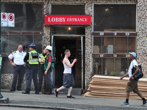 Workers carry plywood into the Regent Hotel after The City of Vancouver's chief building official said that, due to decades of under-investment and mismanagement by the building owners, the structural and life-safety deficiencies at the Regent Hotel constitute an unsafe condition.