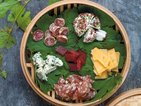 A bamboo steamer lined with grape leaves makes an attractive and practical receptacle for a selection of cheeses and charcuterie. Arrange cookies or bars in the bottom tier for dessert.