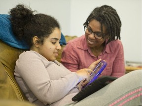 Nicole Kaler with her 17-year-old autistic daughter Maya as she uses two iPads. Maya is non-verbal and has high needs.