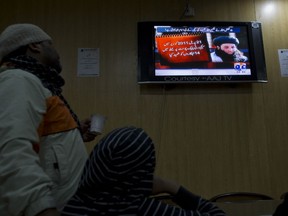 In this Nov. 7, 2013 file photo, people watch a news report on TV about newly selected leader of Pakistani Taliban leader Mullah Fazlullah at a coffee shop in Islamabad, Pakistan.