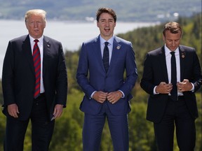 President Donald Trump, Canadian Prime Minister Justin Trudeau, and French President Emmanuel Macron participate in the family photo during the G-7 Summit, Friday, June 8, 2018, in Charlevoix, Canada.