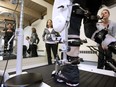 Physiotherapists Hilary Acosta, centre, and Sarah Honkanen look on as Adam de Levie, paralyzed from the waist down, gets mechanical rehabilitation from the Lokomat machine at the NeuroMotion Physiotherapy Clinic in Victoria on April 14, 2011.