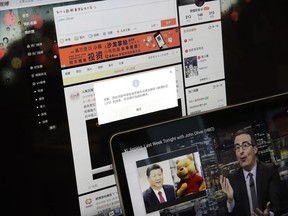 A screen shows a failure message saying a post could not be sent because "the content contains information that violates relevant laws and regulations" on Sina Weibo next to a smaller computer screen showing a "Last Week Tonight" HBO show's host John Oliver with a photo of Chinese President Xi Jinping and Winnie the Pooh, in Beijing, Friday, June 22, 2018. The popular Chinese social media site is blocking users from posting about the show and its HBO host Oliver after the news satire program aired a segment this week making fun of Xi.