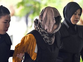 Vietnamese Doan Thi Huong, center, is escorted by police as she arrives for court hearing at Shah Alam High Court, Malaysia, Wednesday, June 27, 2018. Lawyers for two Southeast Asian women accused of poisoning Kim Jong Nam, the estranged half-brother of North Korea's leader Kim Jong Un began their closing arguments Wednesday in a high-profile trial that could send the women to the gallows.