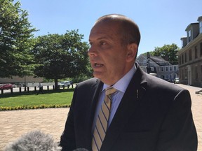 New Brunswick Speaker Chris Collins speaks to reporters in front of the provincial legislature in Fredericton on Monday, July 30, 2018. He issued a public apology for comments that an investigation deemed as harassing.