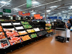An employee stocks the produce section of a Walmart store.