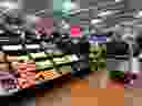 An employee stocks the produce section of a Walmart store.