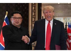 In this file photo taken on June 12 U.S. President Donald Trump, right, and North Korea Leader Kim Jong Un shake hands after a signing ceremony during their historic U.S.-North Korea summit, at the Capella Hotel on Sentosa island in Singapore.