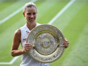 Germany's Angelique Kerber poses with the winner's trophy, the Venus Rosewater Dish, after her women's singles final victory over US player Serena Williams on the twelfth day of the 2018 Wimbledon Championships at The All England Lawn Tennis Club in Wimbledon, southwest London, on July 14, 2018. Kerber won the match 6-3, 6-3.