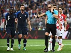 TOPSHOT - Argentinian referee Nestor Pitana gestures as he listens to indications from the Video Assistant Refereeing (VAR) during the Russia 2018 World Cup final football match between France and Croatia at the Luzhniki Stadium in Moscow on July 15, 2018.