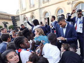 French forward Kylian Mbappe signs autographs at the Elysee Presidential Palace during an official reception July 16 in Paris after French players won the World Cup.