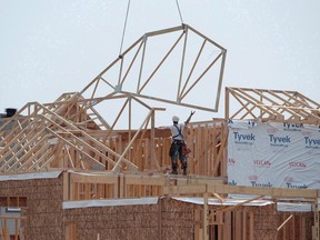Construction workers build new homes in a development in Ottawa on Monday, July 6, 2015. Canada Mortgage and Housing Corp. is making changes intended to make it easier for the self-employed to qualify for a mortgage.