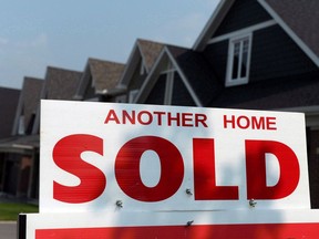 A for sale sign displays a sold home in a housing development in Ottawa on July 6, 2015. The Canada Mortgage and Housing Corporation says Canada's housing sector is facing a high degree of vulnerability to market instability for the eighth straight quarter.