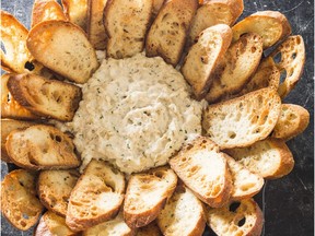 A plate of baked crab dip with crostini.