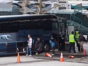 Passengers place their luggage on a Greyhound bus before departing from Vancouver, on Monday July 9, 2018. Greyhound Canada says it is ending its passenger bus and freight services in Alberta, Saskatchewan and Manitoba, and cancelling all but one route in B.C. -- a U.S.-run service between Vancouver and Seattle. As a result, when the changes take effect at the end of October, Ontario and Quebec will be the only regions where the familiar running-dog logo continues to grace Canadian highways.