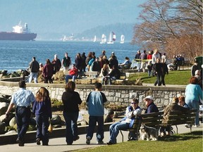 Vancouverites take advantage of the good weather by strolling along the sea wall in Stanley Park.