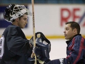 Vancouver Canuck goaltending consultant Ian Clark talks with netminder Dan Cloutier during morning practice at the Vancouver Canucks 2002 training camp in Kamloops. Clark has rejoined the Canucks and will work under Cloutier in the goaltending department.
