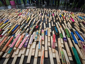 People stand over 2,224 wooden stakes — representing the number of confirmed overdose deaths in B.C. over the last three years, many of them painted with names of overdose victims — at Oppenheimer Park in downtown Vancouver last September. Canada’s opioid overdose crisis is primarily about illegal street drugs and not legal prescriptions, says commentator Susan Martinuk.