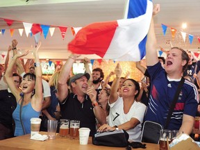 France supporters at the American Pub in Vancouver celebrate their team's 4-2 win over Croatia in the 2018 World Cup Final.