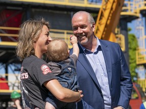 B.C. Premier John Horgan plays with Jack James, son of Danielle Shaw, an iron worker apprentice, during a press conference at BCIT in Burnaby, BC, July, 16, 2017.