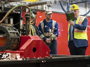 B.C. Premier John Horgan, right, spent the better part of 30 minutes on July 16 trumpeting the virtues of CBAs without ever mentioning the union-favouring provisions.