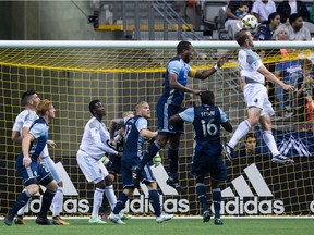 Minnesota United's Brent Kallman (right) and Vancouver Whitecaps Kendall Waston and Tony Tchani vie for the ball off a corner kick during a Major League Soccer game last season at B.C. Place Stadium.