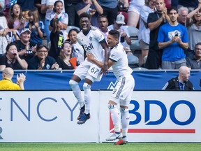 Vancouver Whitecaps' Alphonso Davies, left, and Anthony Blondell celebrate Davies' goal against Minnesota United during the second half of an MLS soccer game in Vancouver, on Saturday July 28, 2018.
