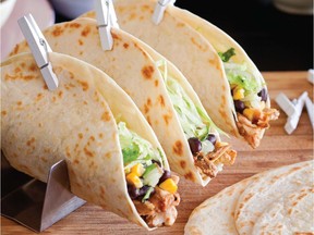 The meat for Caren McSherry's Soft Pulled Chicken Tacos is cooked in tomato salsa and the finished dish is garnished with corn salsa. Mini clothespins ­ available at craft stores and many online sources ­ are handy for holding together the assembled tacos.