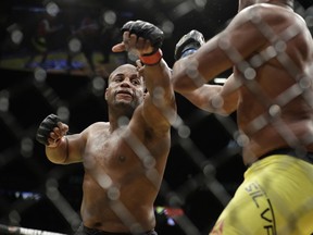 Daniel Cormier, taking a swing at Anderson Silva during their UFC 200 light-heavyweight bout in July 2016, is looking at this weekend’s title fight against heavyweight champion Stipe Miocic to join the exclusive group of fighters to win UFC titles in two divisions and join Conor McGregor as the only fighters to hold two belts at the same time.