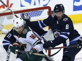 Winnipeg Jets defenceman Jacob Trouba (right) checks Minnesota Wild forward Jason Zucker during Game 1 of their first-round NHL playoff series.