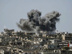 This Thursday, July 5, 2018 file photo provided by Nabaa Media, a Syrian opposition media outlet, shows smoke rising over buildings that were hit by Syrian government forces bombardment, in Daraa province, southern Syria.