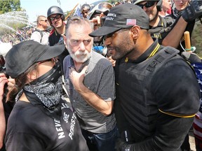 A man intervenes during an argument between protesters during a rally for gun rights' laws and free speech at Tom McCall Waterfront Park on August 4, 2018 in Portland, Oregon. The rally was organized by the group Patriot Prayer, also attended by the affiliated group Proud Boys, which drew counter protesters and members of the anti-fascist group Antifa.