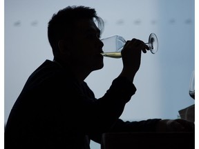 A visitor drinks a glass of wine during a tasting event at Vinexpo in Hong Kong on May 24, 2016.