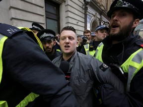 In this file photo taken on April 01, 2017 Stephen Christopher Yaxley-Lennon, AKA Tommy Robinson, former leader of the right-wing EDL (English Defence League) is escorted away by police from a Britain First march and an English Defence League march in central London, 2017 following the deadly terror attack against the British Parliament on March 22.