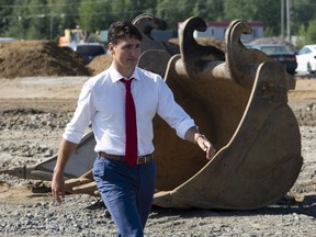 Prime Minister Justin Trudeau walks through a construction area before participating in a ground breaking ceremony for an Amazon distribution centre in Ottawa, Monday August 20, 2018.