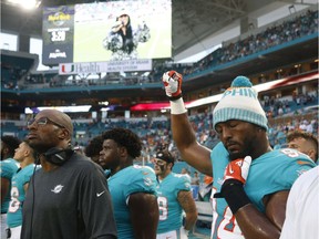 Miami Dolphins' defensive end Robert Quinn raises his right fist during the singing of the national anthem before the NFL team's pre-season game against the Tampa Bay Buccaneers on Aug. 9 in Miami Gardens, Fla.