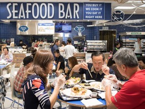 People eat at a seafood bar at T&T Supermarket's newest location, in Richmond. Shoppers can purchase fresh seafood in the store and have it steamed or baked to be eaten on site. Grocery stores increasingly blur the line between supermarkets and restaurants with large chains adding take-out meals to their shelves, hot food counters where chefs make dishes to order and even full-service restaurants. Dubbed grocerants, these combination spaces serve a time-strapped population that values convenience.
