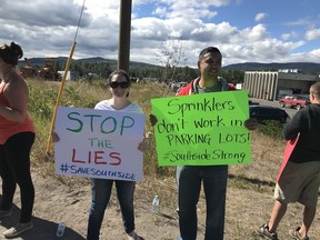 Frustrated protesters in Burns Lake assembled Saturday around 28 trucks loaded with sprinklers, hoses and other gear that sat idle in a grocery store parking lot.