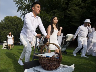 People arrive for the 7th Annual Le Dîner en Blanc  at the VanDusen Botanical Garden in Vancouver on Thursday.