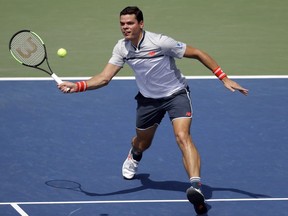 Milos Raonic returns the ball to Gilles Simon during the second round of the U.S. Open in New York, Wednesday, Aug. 29, 2018.