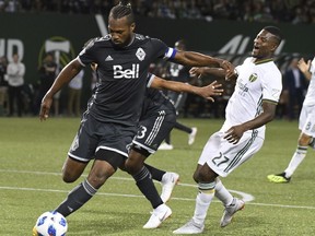 Vancouver Whitecaps' Kendall Waston (4) controls the ball next to Portland Timbers' Dairon Asprilla during an MLS soccer match Saturday, Aug. 11, 2018, in Portland, Ore.