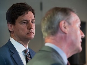 B.C. Attorney General David Eby, back left, listens as Peter German, former deputy commissioner of the RCMP, speaks about his review of anti-money laundering practices in the province during a news conference, in Vancouver, on Wednesday June 27, 2018. Money-laundering operations through Vancouver-area casinos is tied to the opioid crisis and the real-estate market in British Columbia, Eby said Wednesday as he released an independent report that details how organized crime groups used the gaming industry.THE CANADIAN PRESS/Darryl Dyck ORG XMIT: VCRD107