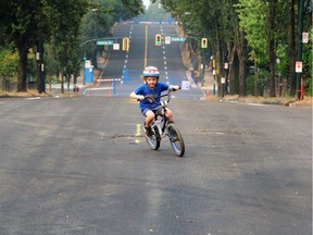 Banksy Mosuk rides his bike on East 1st Ave as the street remains closed for gas line repairs in Vancouver, BC., August 22, 2018.